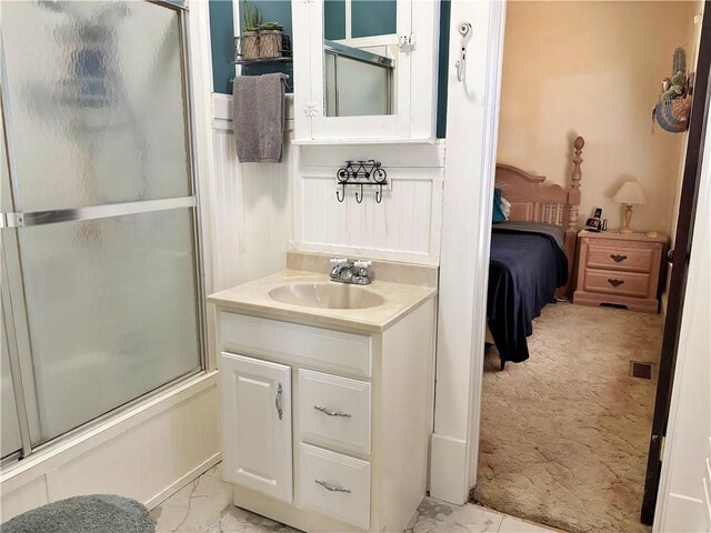 ensuite bathroom with marble finish flooring, vanity, and shower / bath combination with glass door