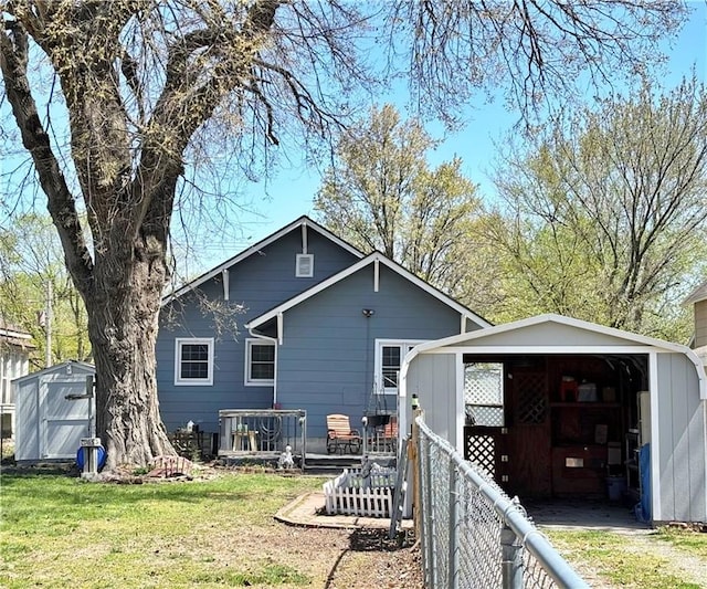 rear view of property featuring an outbuilding and a shed