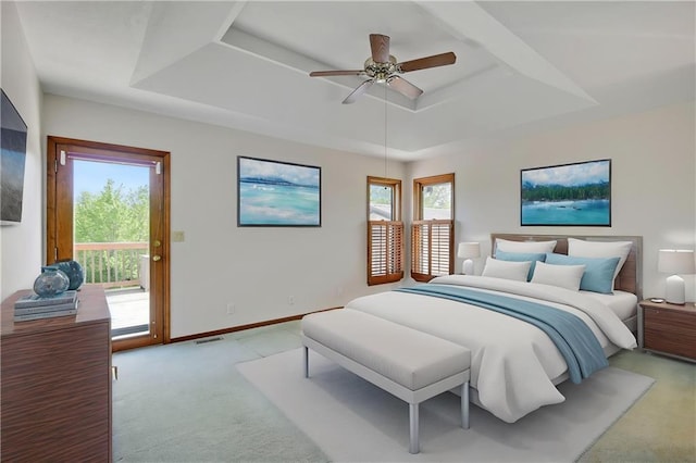 bedroom featuring a tray ceiling, light colored carpet, access to exterior, baseboards, and ceiling fan