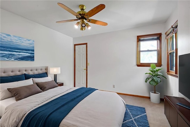 carpeted bedroom featuring baseboards and a ceiling fan