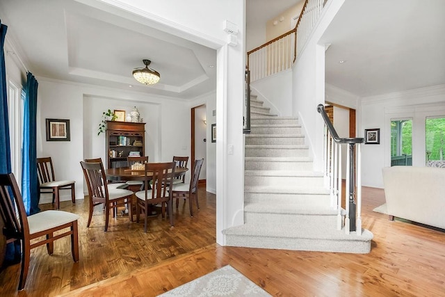 7711 N Montgall Ave, Kansas City, MO 64119 - dining space featuring stairs, wood finished floors, a tray ceiling, and crown molding