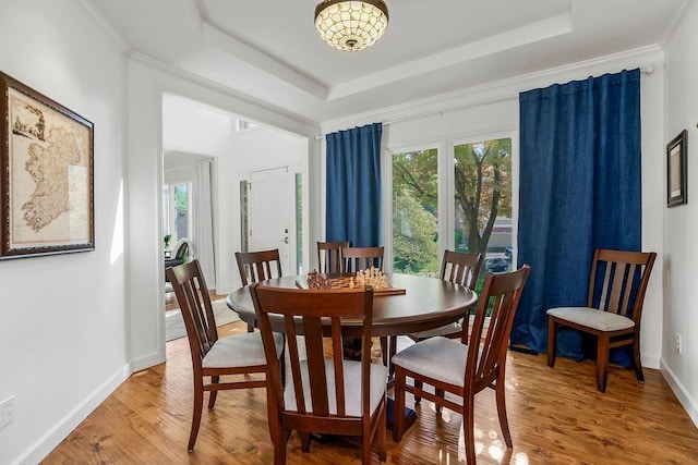 7711 N Montgall Ave, Kansas City, MO 64119 - dining space featuring a raised ceiling, wood finished floors, baseboards, and a chandelier