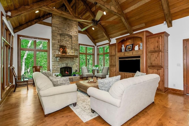 7711 N Montgall Ave, Kansas City, MO 64119 - living room featuring a fireplace, wooden ceiling, wood finished floors, a ceiling fan, and healthy amount of natural light