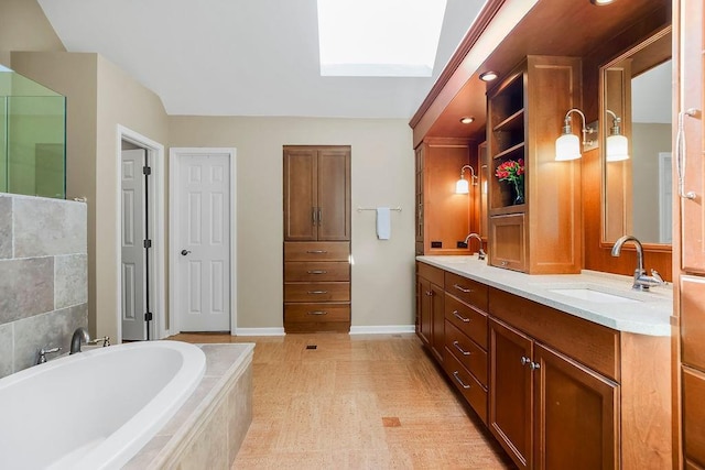 7711 N Montgall Ave, Kansas City, MO 64119 - full bath featuring a skylight, tiled tub, double vanity, and baseboards