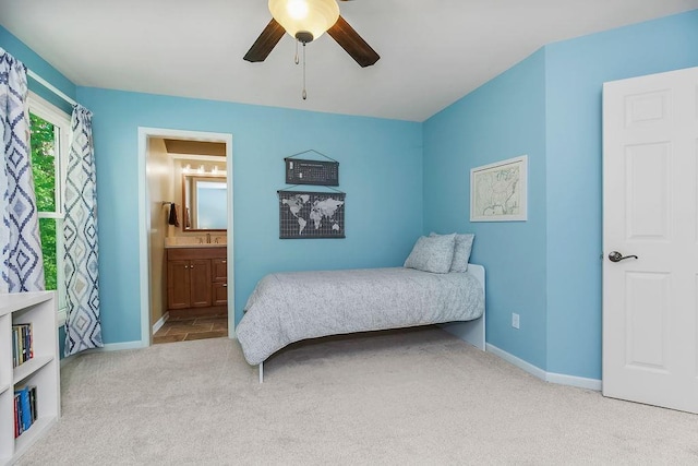 7711 N Montgall Ave, Kansas City, MO 64119 - bedroom featuring carpet flooring, baseboards, connected bathroom, a ceiling fan, and a sink