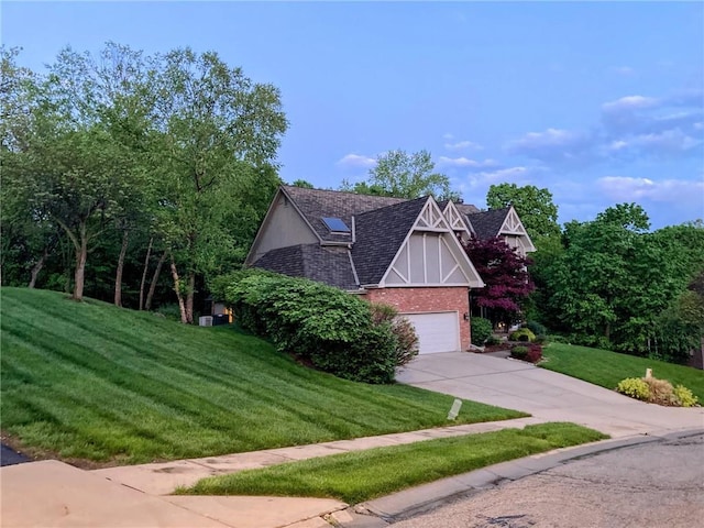 7711 N Montgall Ave, Kansas City, MO 64119 - view of front of house with concrete driveway, brick siding, a front yard, and a garage