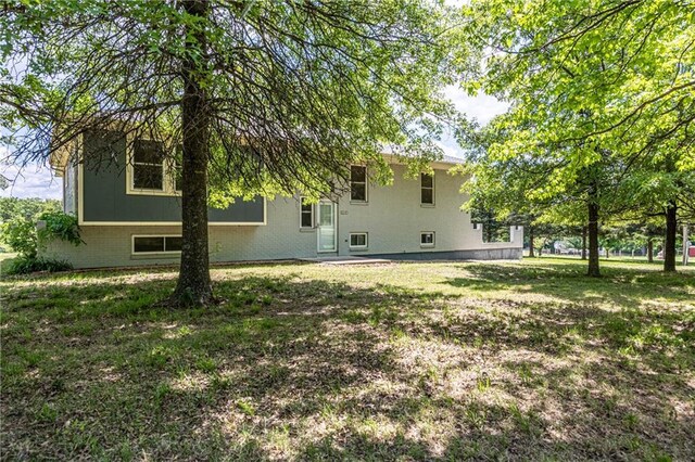 537 NE State Route 13th Hwy, Warrensburg, MO 64093 - rear view of house featuring brick siding and a yard
