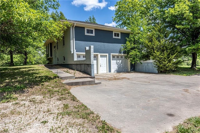 537 NE State Route 13th Hwy, Warrensburg, MO 64093 - view of front of property with driveway, stucco siding, and an attached garage