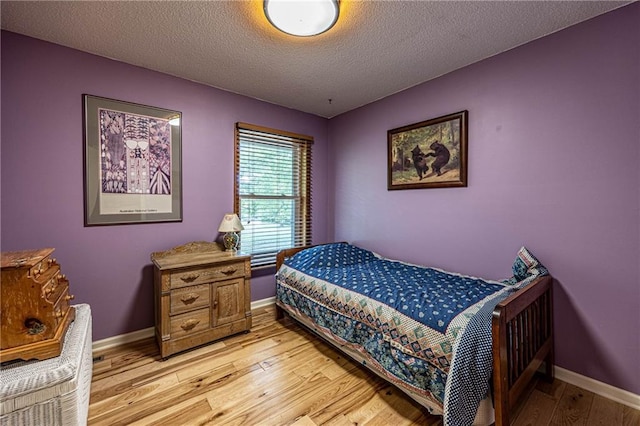 537 NE State Route 13th Hwy, Warrensburg, MO 64093 - bedroom with light wood-style floors, a textured ceiling, and baseboards