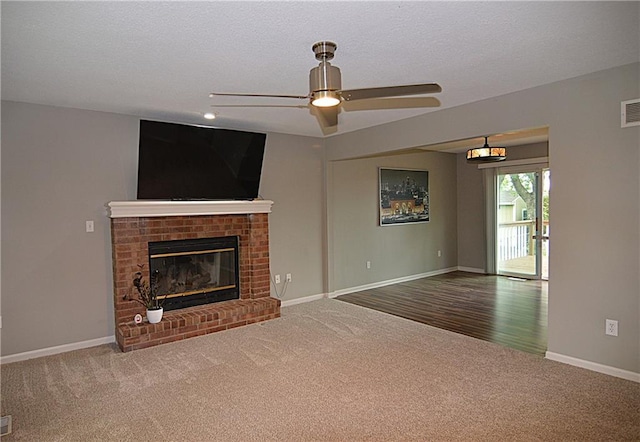 1748 NE Ridgeview Dr, Lees Summit, MO 64086 - unfurnished living room with carpet flooring, a ceiling fan, a fireplace, baseboards, and a textured ceiling