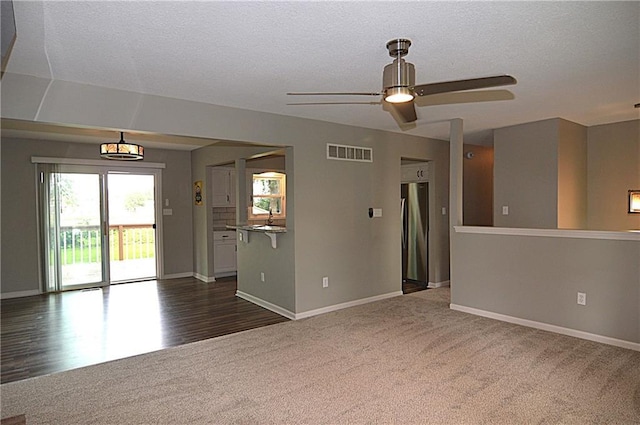 1748 NE Ridgeview Dr, Lees Summit, MO 64086 - unfurnished room with dark carpet, baseboards, a ceiling fan, and a textured ceiling
