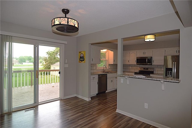 1748 NE Ridgeview Dr, Lees Summit, MO 64086 - kitchen with stainless steel appliances, white cabinetry, backsplash, a sink, and a peninsula