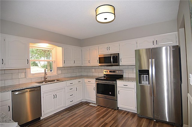 1748 NE Ridgeview Dr, Lees Summit, MO 64086 - kitchen with appliances with stainless steel finishes, a sink, light stone countertops, white cabinetry, and a textured ceiling
