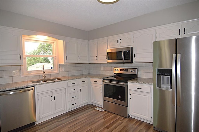 1748 NE Ridgeview Dr, Lees Summit, MO 64086 - kitchen featuring appliances with stainless steel finishes, a sink, white cabinetry, dark wood-type flooring, and a textured ceiling