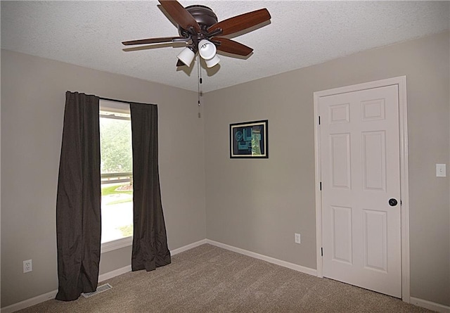 1748 NE Ridgeview Dr, Lees Summit, MO 64086 - carpeted empty room featuring ceiling fan, plenty of natural light, a textured ceiling, and baseboards