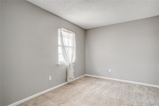 5516 66th Ter, Kansas City, MO 64151 - carpeted empty room with baseboards and a textured ceiling