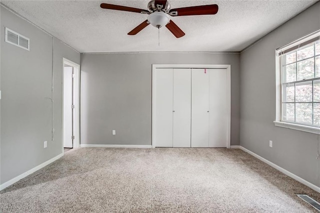 5516 66th Ter, Kansas City, MO 64151 - unfurnished bedroom with carpet flooring, a textured ceiling, a closet, baseboards, and ceiling fan