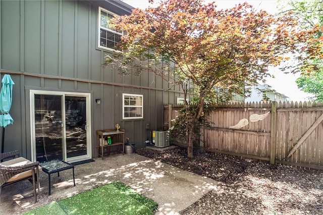 5516 66th Ter, Kansas City, MO 64151 - back of property with board and batten siding, fence, central AC, and a patio