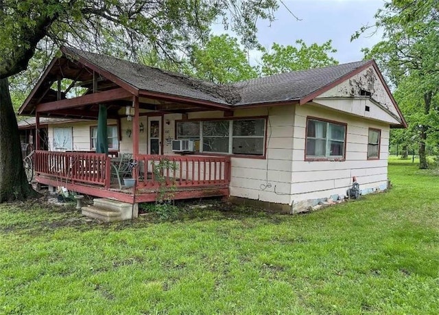 view of front facade with covered porch, a front yard, and cooling unit