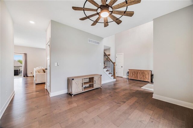 spare room featuring a ceiling fan, stairs, wood finished floors, baseboards, and recessed lighting