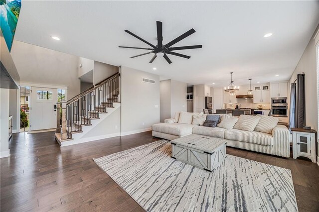 living area featuring stairs, ceiling fan, baseboards, a chandelier, and recessed lighting