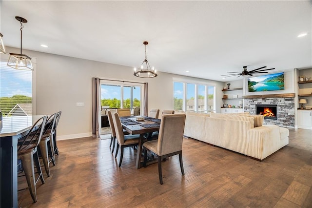 dining area with recessed lighting, baseboards, dark wood-style flooring, a stone fireplace, and ceiling fan