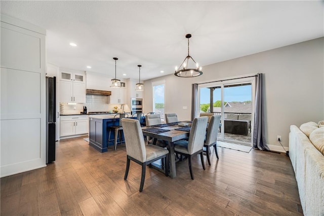 dining area with recessed lighting, a chandelier, dark wood finished floors, and baseboards