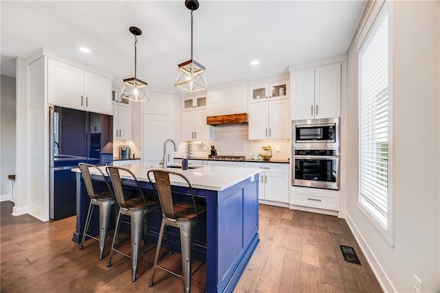 kitchen with appliances with stainless steel finishes, backsplash, dark wood-style floors, a sink, and recessed lighting