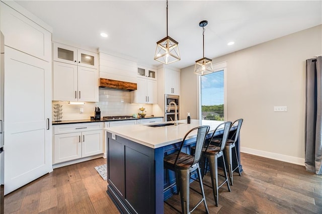 kitchen featuring a sink, baseboards, dark wood-type flooring, recessed lighting, and tasteful backsplash