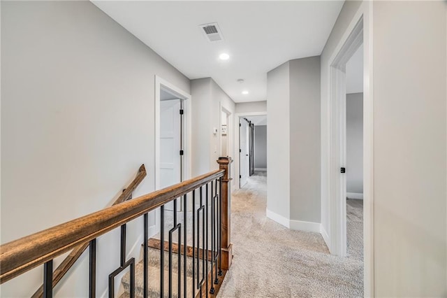 corridor featuring light colored carpet, an upstairs landing, recessed lighting, and baseboards