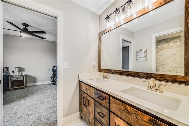 full bathroom with baseboards, ceiling fan, and double vanity