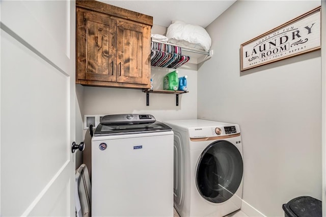 washroom featuring cabinet space, washing machine and dryer, and baseboards