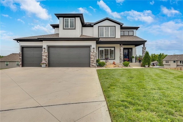 prairie-style house with a front lawn, stucco siding, driveway, and an attached garage