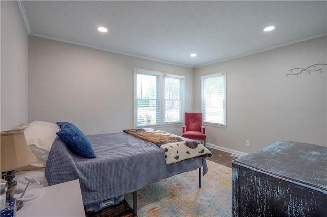 bedroom with crown molding, wood finished floors, recessed lighting, and baseboards