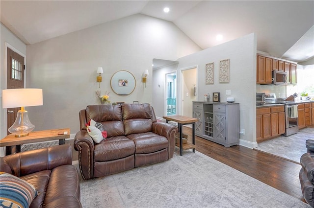 living area featuring light wood-style flooring, lofted ceiling, and recessed lighting