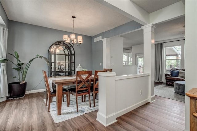 1849 W Cedar St, Olathe, KS 66061 - dining room with decorative columns, wood finished floors, and a chandelier