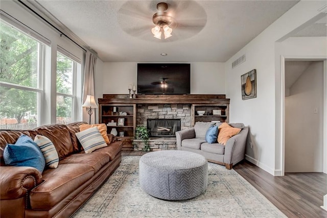 1849 W Cedar St, Olathe, KS 66061 - living area featuring wood finished floors, ceiling fan, and a stone fireplace