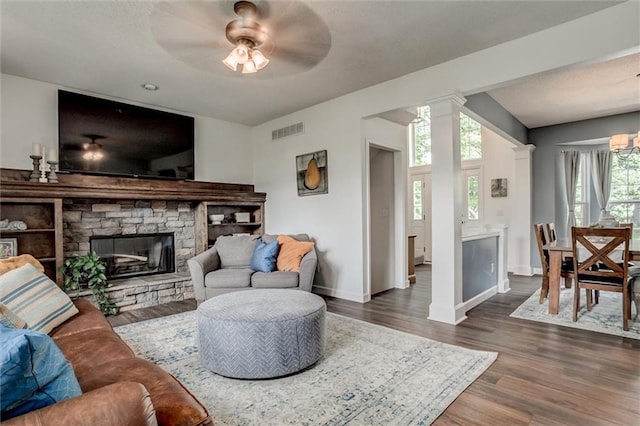 1849 W Cedar St, Olathe, KS 66061 - living area with dark wood-type flooring, a fireplace, a ceiling fan, and decorative columns