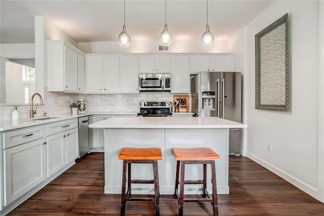 1849 W Cedar St, Olathe, KS 66061 - kitchen with appliances with stainless steel finishes, decorative backsplash, a kitchen island, a kitchen bar, and light countertops