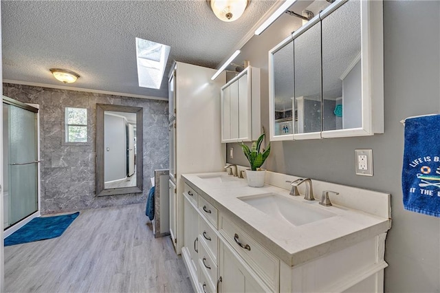 33 Lakeview Ln, Linn Valley, KS 66040 - full bath featuring a skylight, a textured ceiling, wood finished floors, double vanity, and a shower with shower door