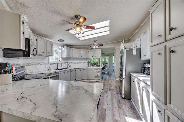 33 Lakeview Ln, Linn Valley, KS 66040 - kitchen with a ceiling fan, appliances with stainless steel finishes, a sink, a skylight, and decorative backsplash