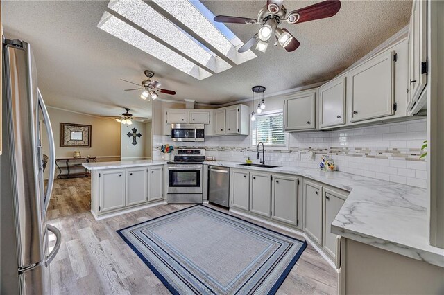 33 Lakeview Ln, Linn Valley, KS 66040 - kitchen with stainless steel appliances, a sink, ceiling fan, a peninsula, and a textured ceiling