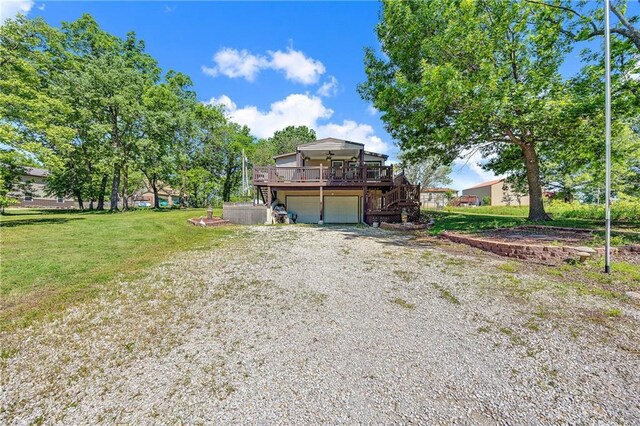 33 Lakeview Ln, Linn Valley, KS 66040 - view of front of house featuring a wooden deck, stairs, an attached garage, a front yard, and gravel driveway