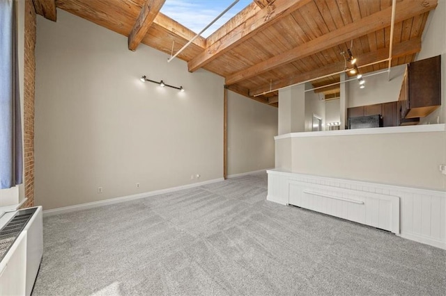308 W 8th St Unit 712, Kansas City, MO 64105 - unfurnished living room with wooden ceiling with exposed beams, light colored carpet, and a skylight