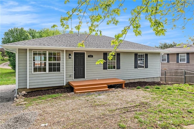 single story home with fence and a shingled roof