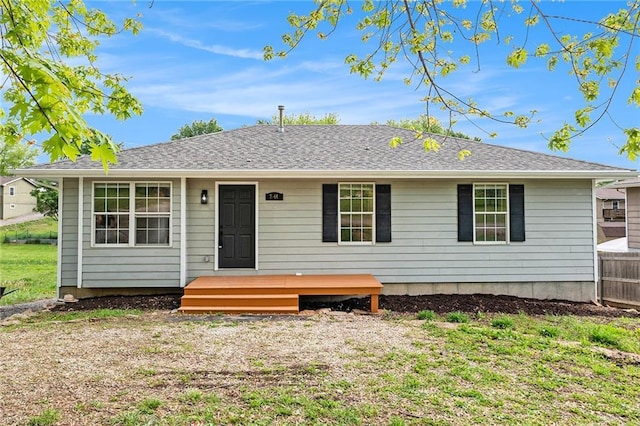 back of property with fence and a wooden deck