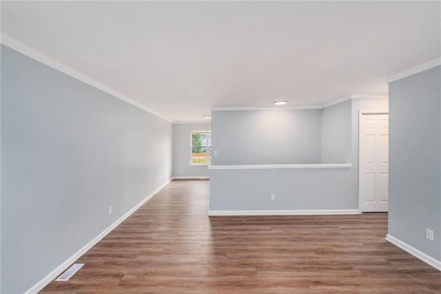 unfurnished room featuring crown molding, wood finished floors, and baseboards