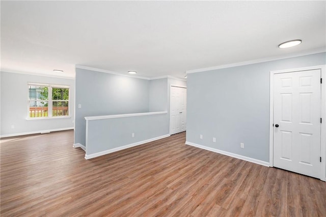 unfurnished room featuring crown molding, wood finished floors, and baseboards
