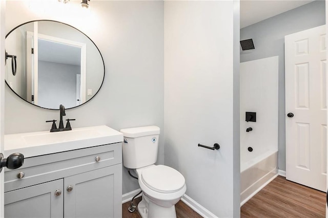 bathroom featuring toilet, wood finished floors, vanity, and baseboards