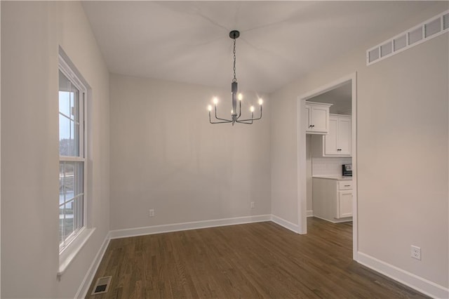 6106 NE 118th St, Kansas City, MO 64156 - unfurnished dining area featuring a chandelier, baseboards, and dark wood-type flooring